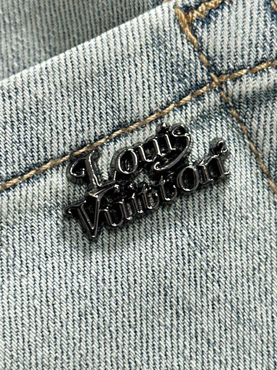 Denim fabric with LV logo metal embroidery and gold-tone stitching detail