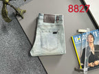 Light blue denim jeans laid flat with back logo patch and pockets
