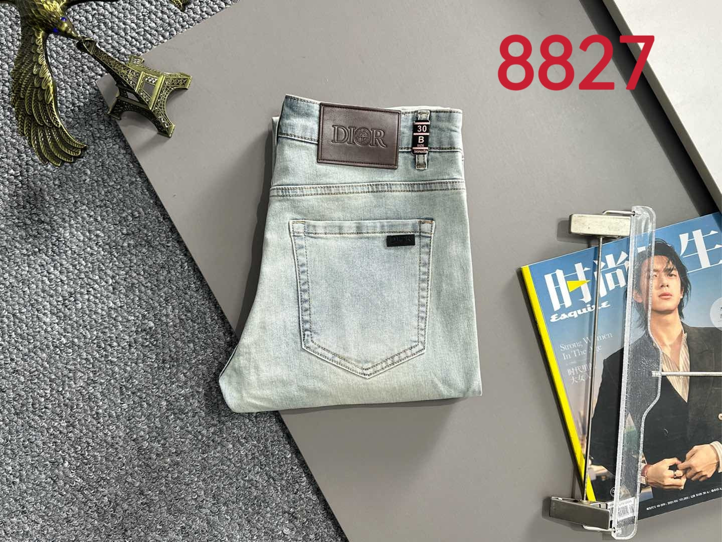 Light blue denim jeans laid flat with back logo patch and pockets