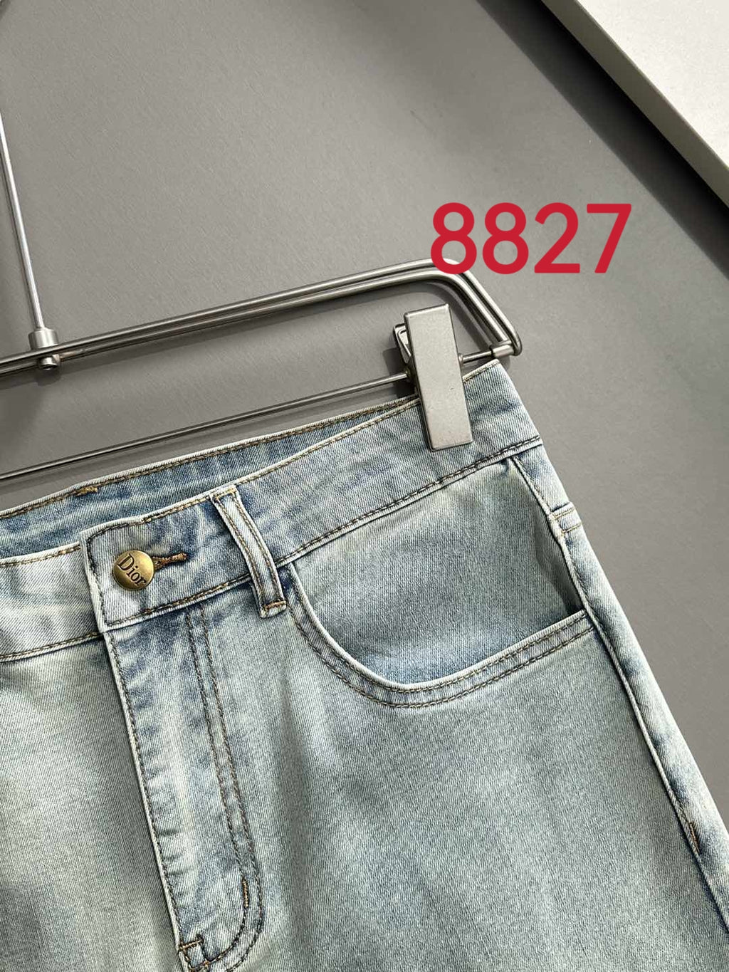 Light blue denim jeans waistband with logo button and front seam stitching