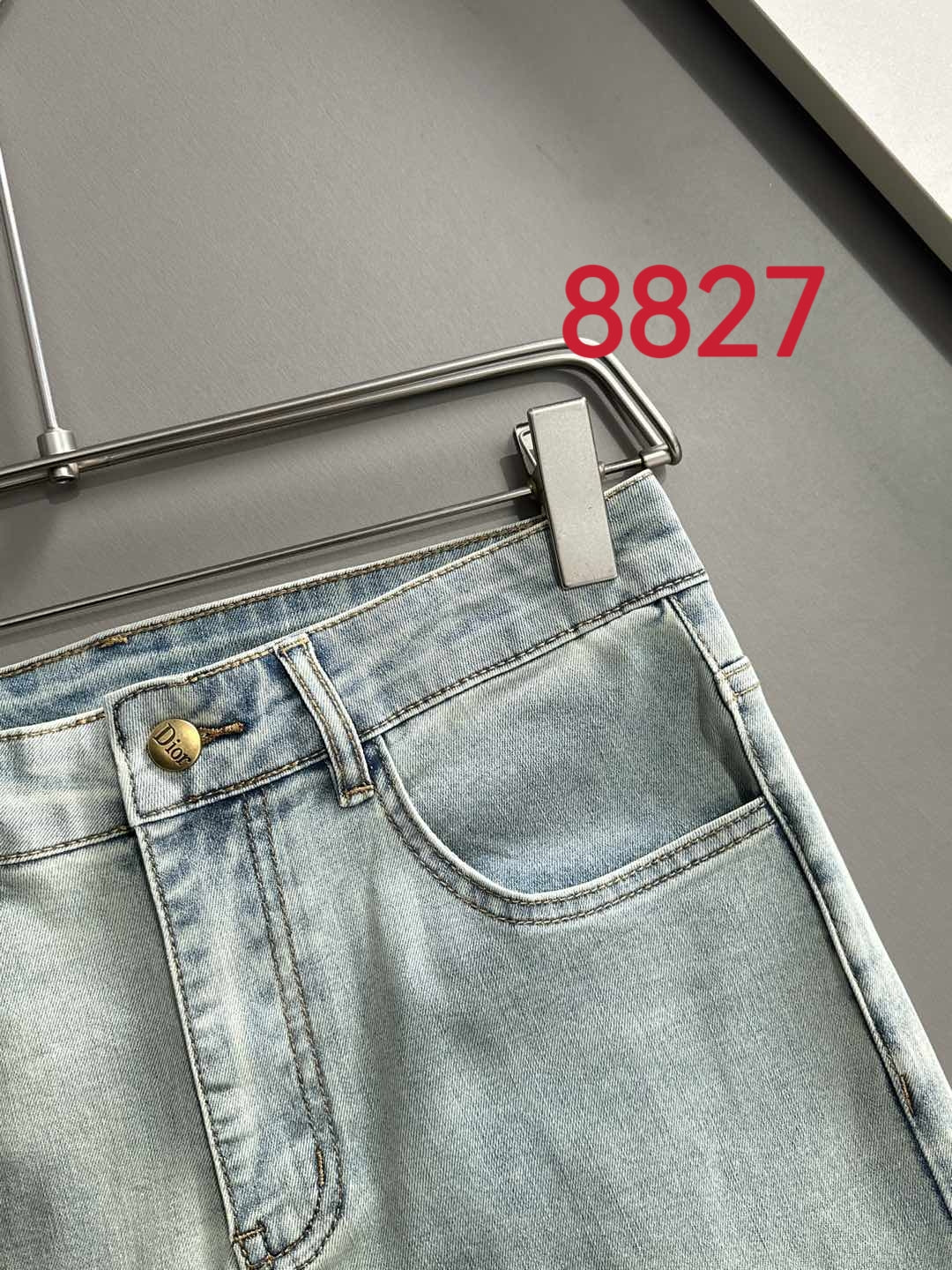 Light blue denim jeans waistband with logo button and front seam stitching