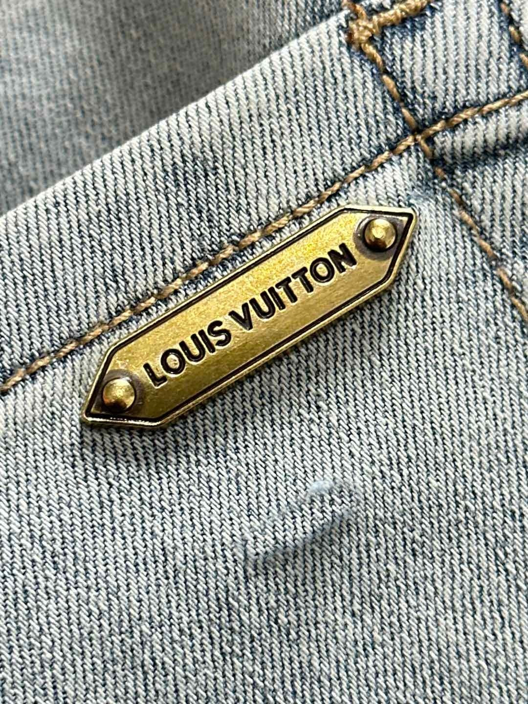 Louis Vuitton metal logo label on light-wash denim seam