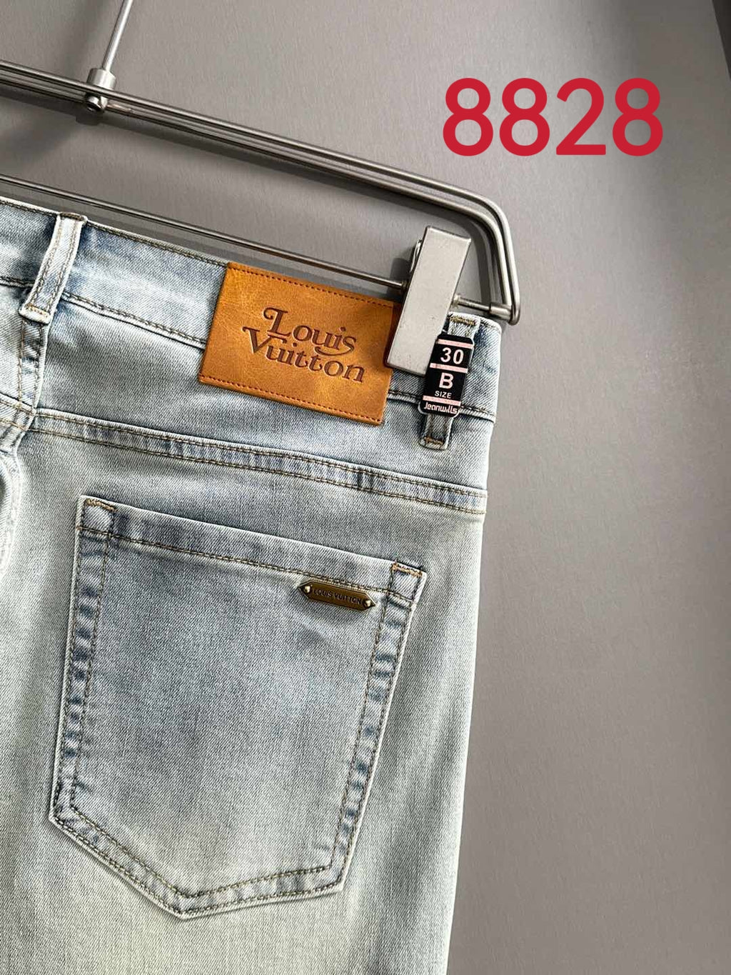 Louis Vuitton logo patch on light-wash denim jeans back pocket