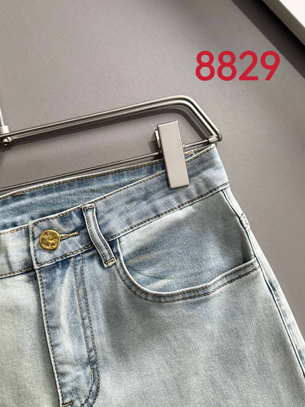 Light-wash denim jeans close-up of front pocket and curved waistband seam