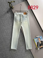 Light-wash denim jeans with stitched pockets and waistband, hanging on a hanger
