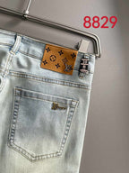 Light-wash denim jeans back pocket close-up with Louis Vuitton-style logo patch
