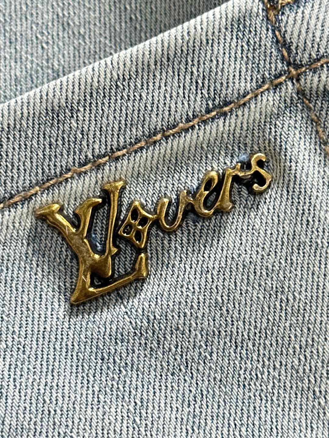 Light-wash denim jeans embroidered script logo detail on the front