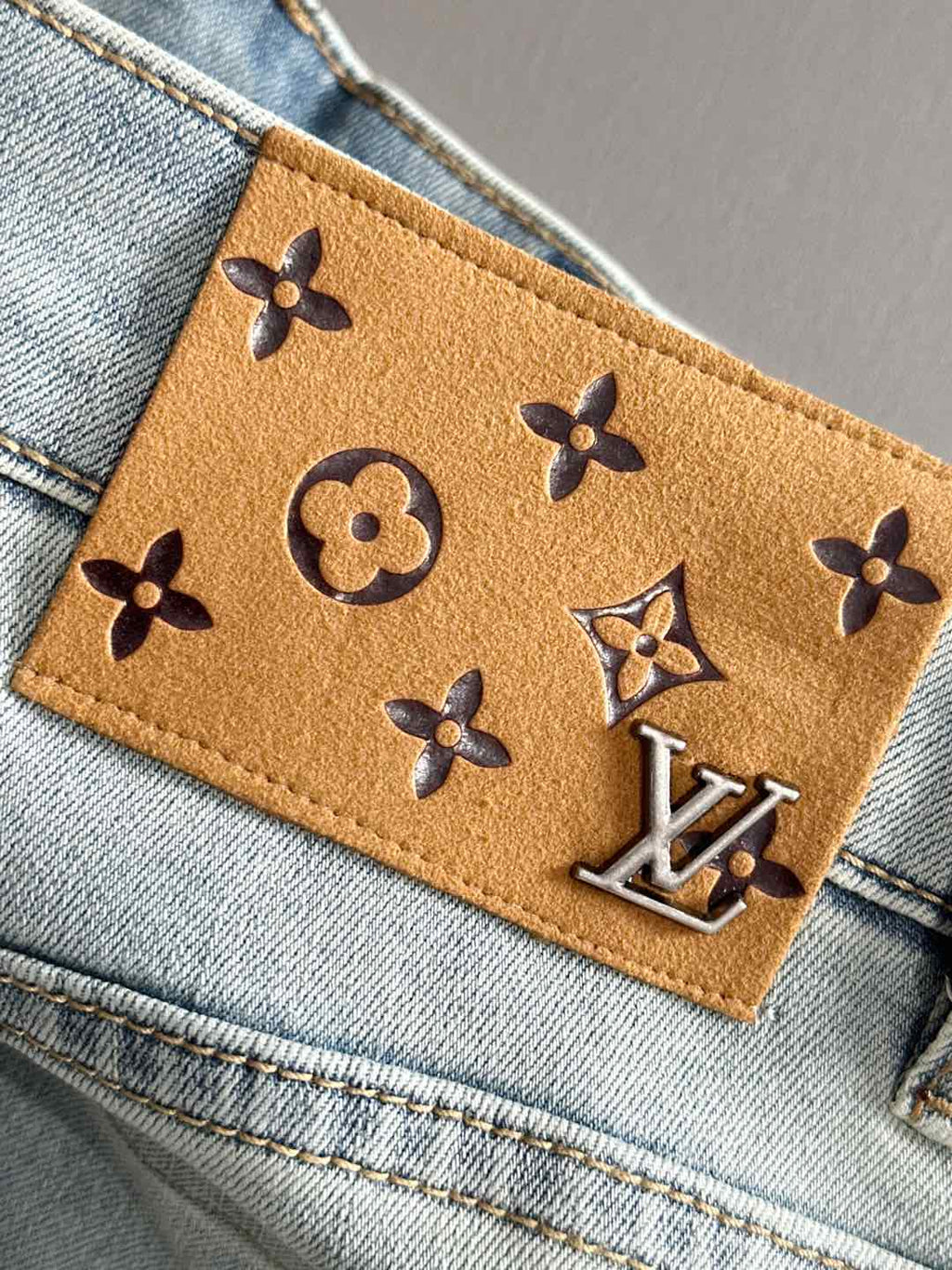 Light-wash denim jeans leather logo patch with monogram symbols