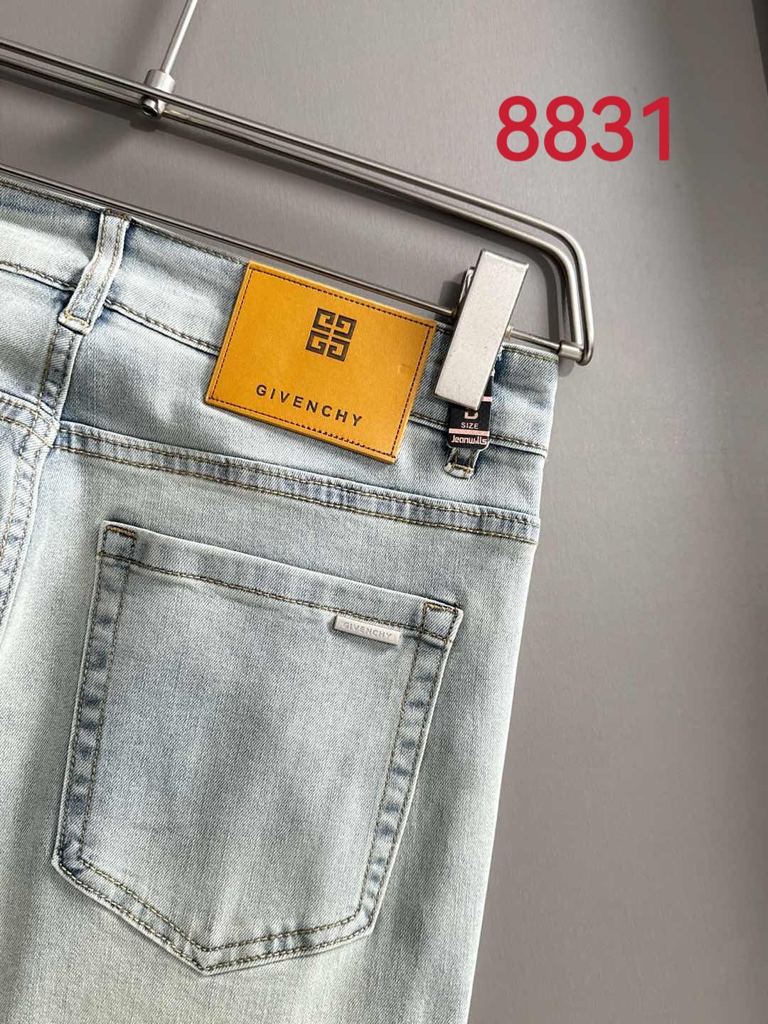 Givenchy light-wash jeans, close-up of front pocket and logo patch