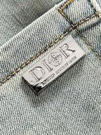 Dior leather brand label on light-wash denim, stitched hem and seams