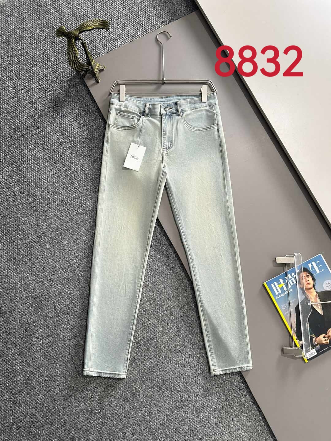 Light-wash Dior denim pants on hanger, five-pocket style with belt loops