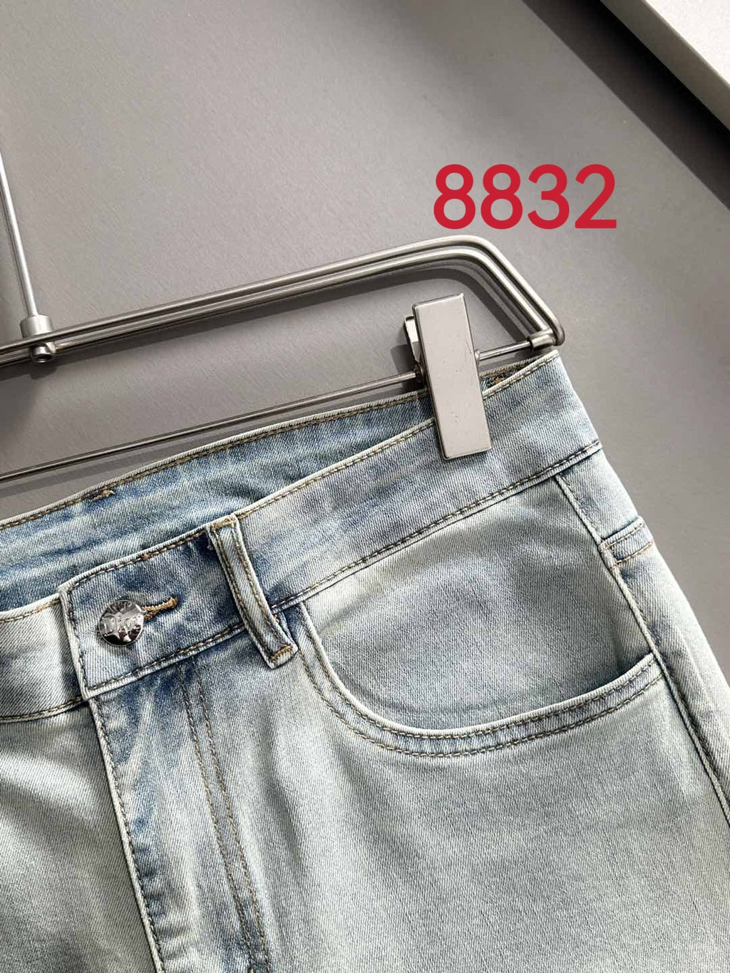 Light-wash Dior denim pants close-up, waistband and stitched front pocket