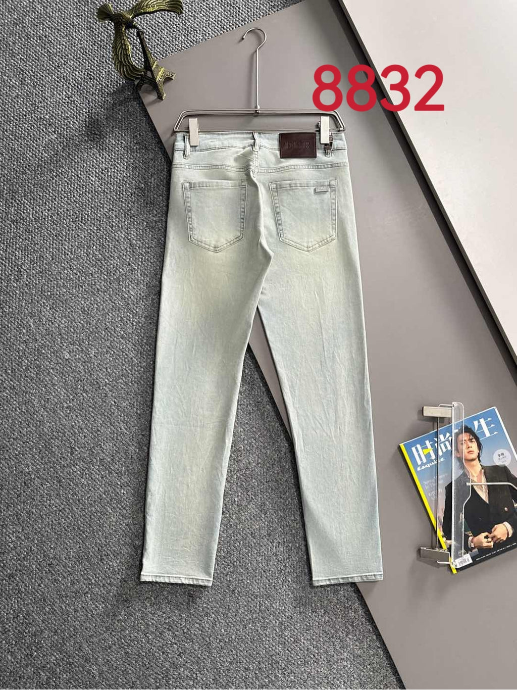 Light-wash Dior denim pants on hanger, straight legs with back pockets