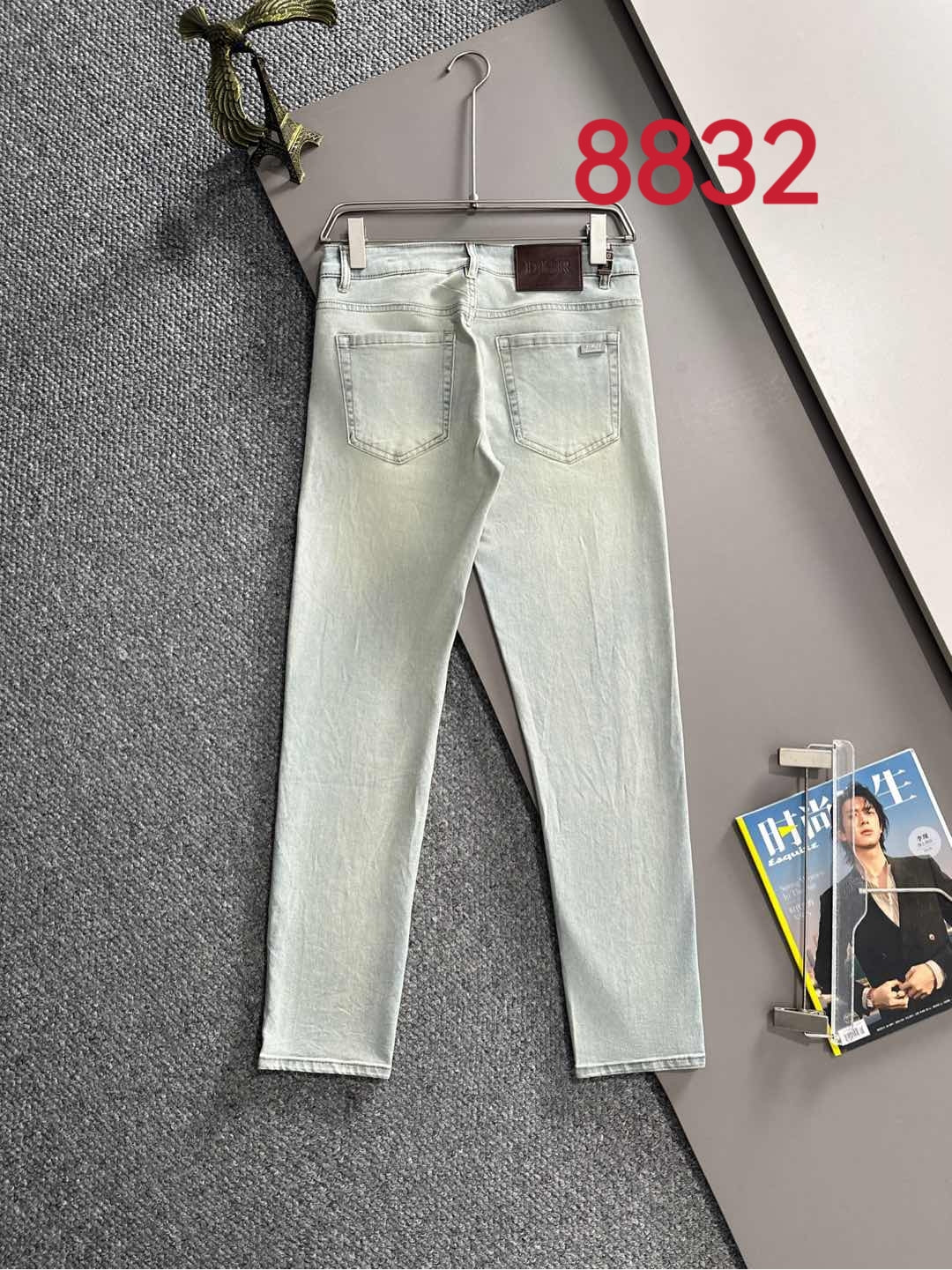 Light-wash Dior denim pants on hanger, straight legs with back pockets