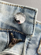 Dior jeans button and zipper close-up on light-wash denim pocket