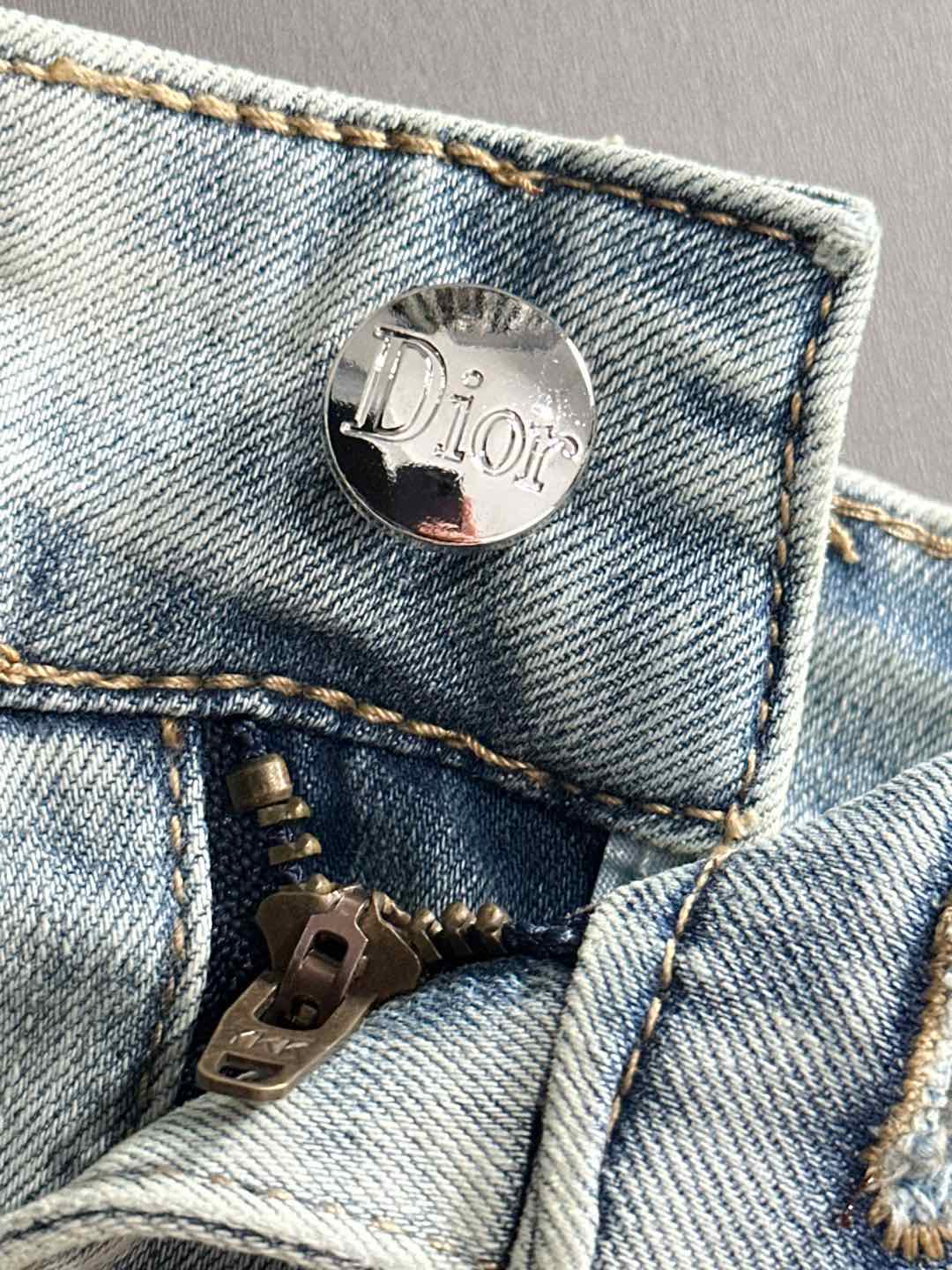 Dior jeans button and zipper close-up on light-wash denim pocket