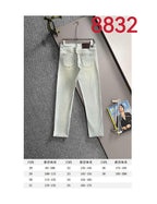 Light-wash Dior denim pants on hanger with size chart panel below
