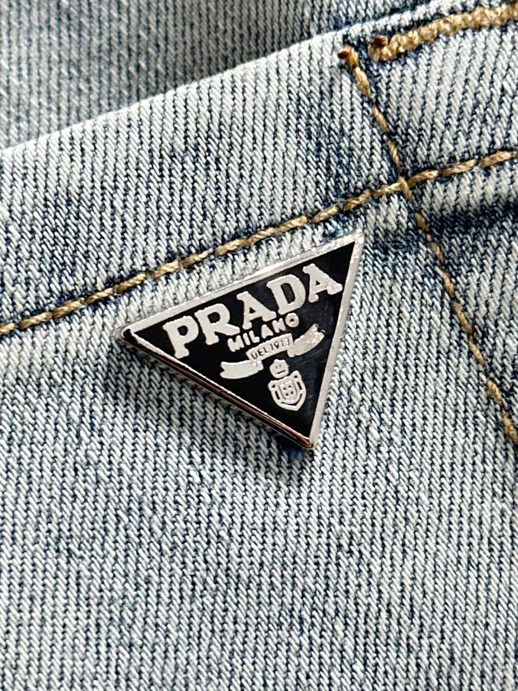 Denim pants with triangular Prada logo patch on coin-pocket area