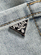 Denim pants with triangular Prada logo patch on coin-pocket area