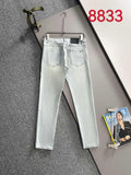 Light blue denim pants on hangers, five-pocket design and belt loops