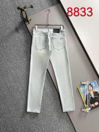 Light blue denim pants on hangers, five-pocket design and belt loops