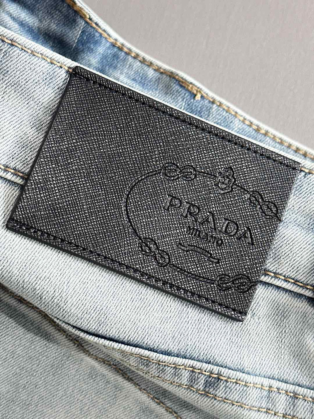 Denim pants with embossed brand label at waistband and visible stitching