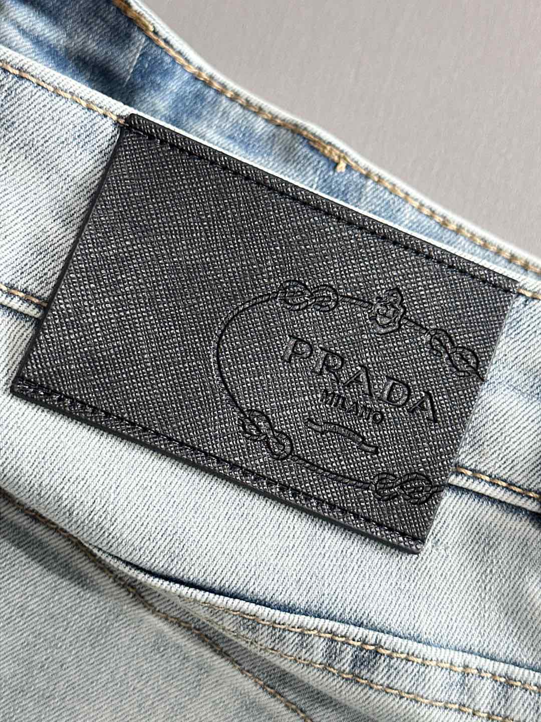 Denim pants with embossed brand label at waistband and visible stitching