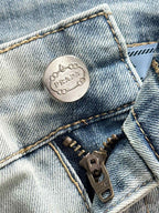 Prada logo metal button on light-wash denim front