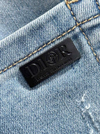 Black Dior leather logo label stitched on light blue denim waistband