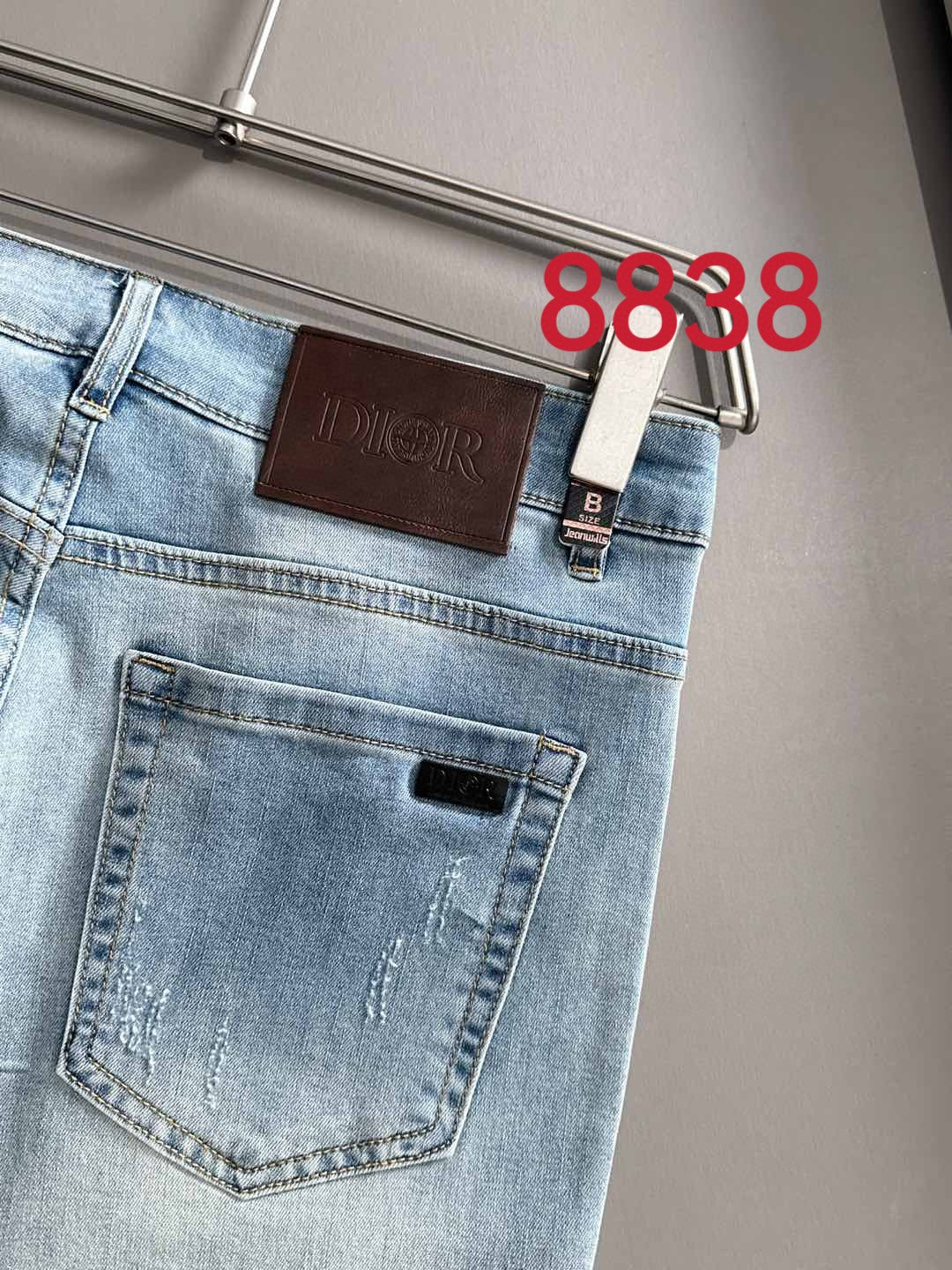 Light blue denim pants front pocket with brown Dior leather logo patch