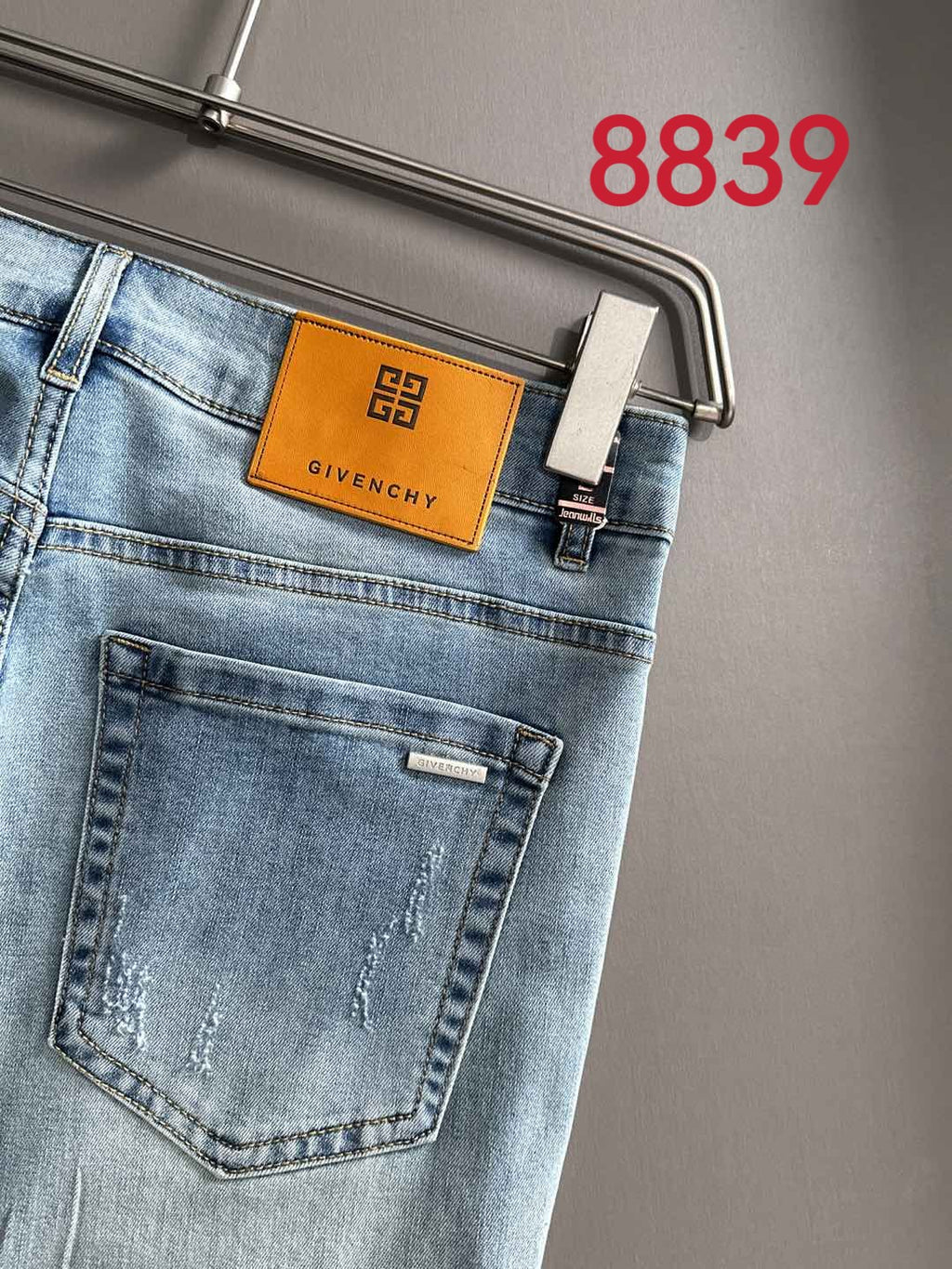 Light blue denim back pocket with orange GIVENCHY patch on the waistband.