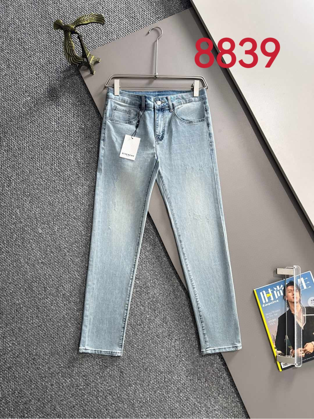 Light blue denim jeans on a hanger, showing front pockets and a side tag.