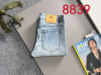 Light blue denim jeans folded flat with orange GIVENCHY logo patch and tag.
