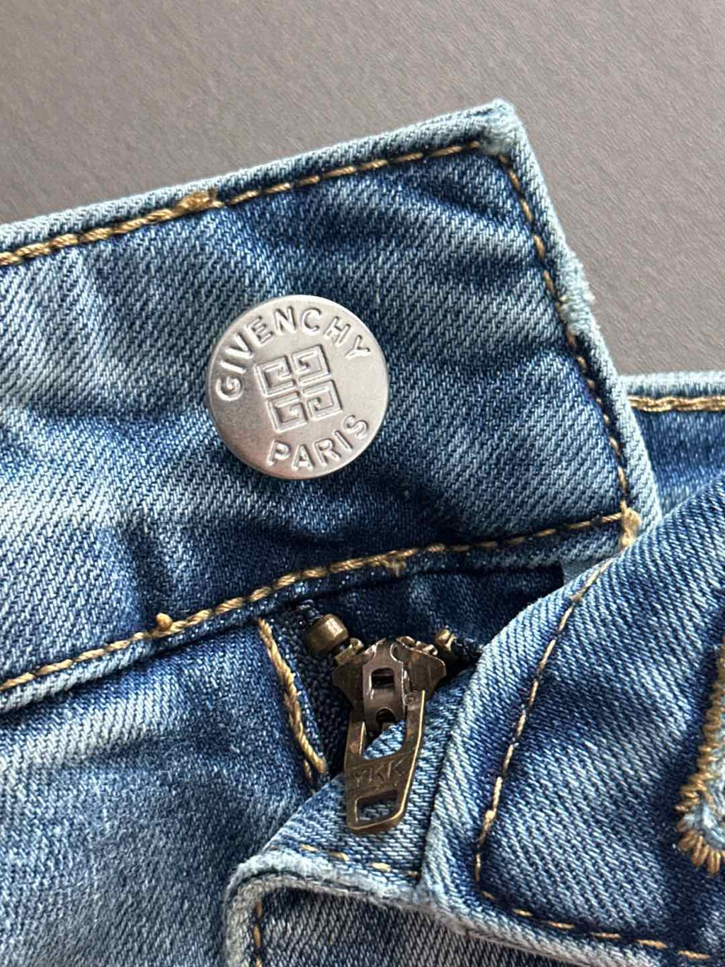 Light blue denim coin pocket with GIVENCHY logo and zipper pull hardware.