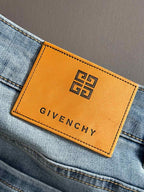 Orange GIVENCHY leather patch with logo on light blue denim.