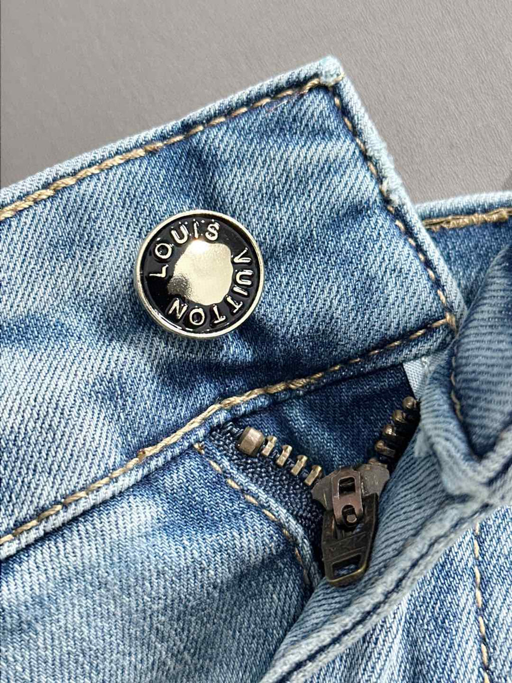 Louis Vuitton metal button with circular LV Monogram on denim