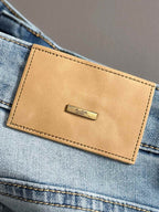 Louis Vuitton tan leather logo patch on light blue denim
