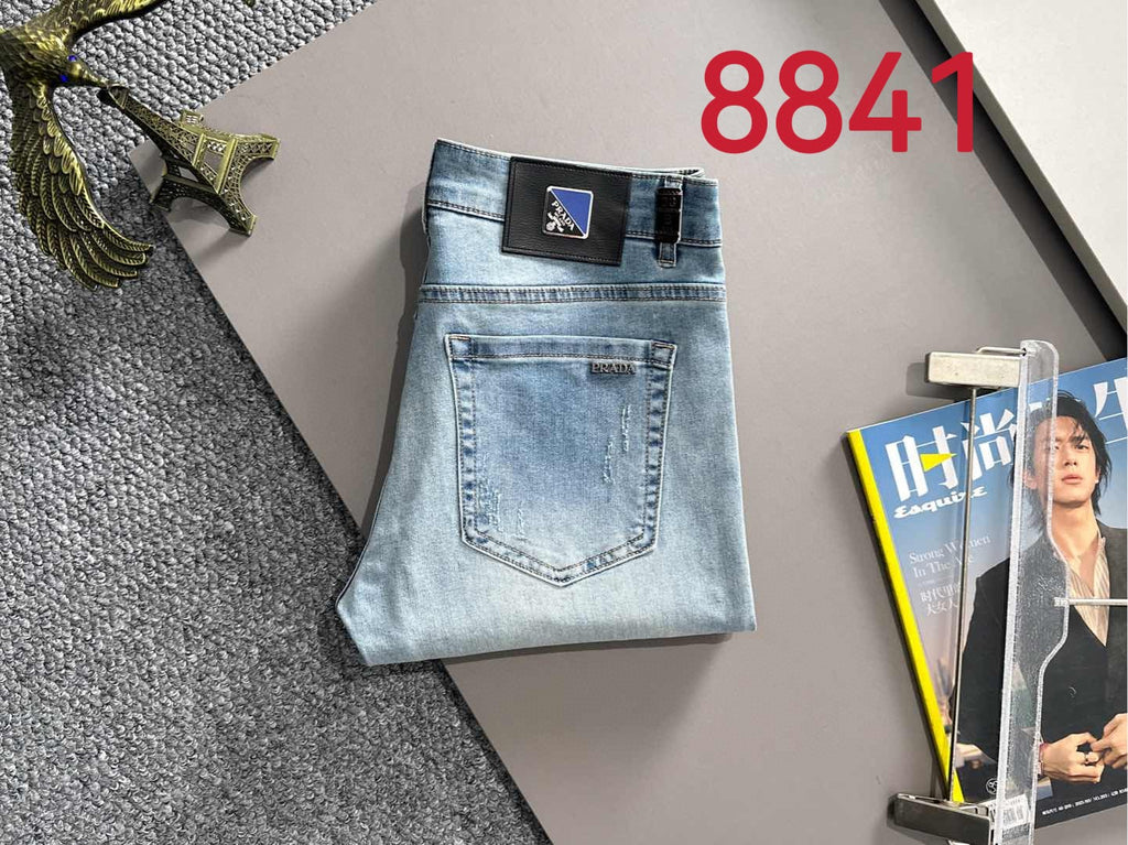 Light blue denim jeans laid flat, showing front pocket and button closure.