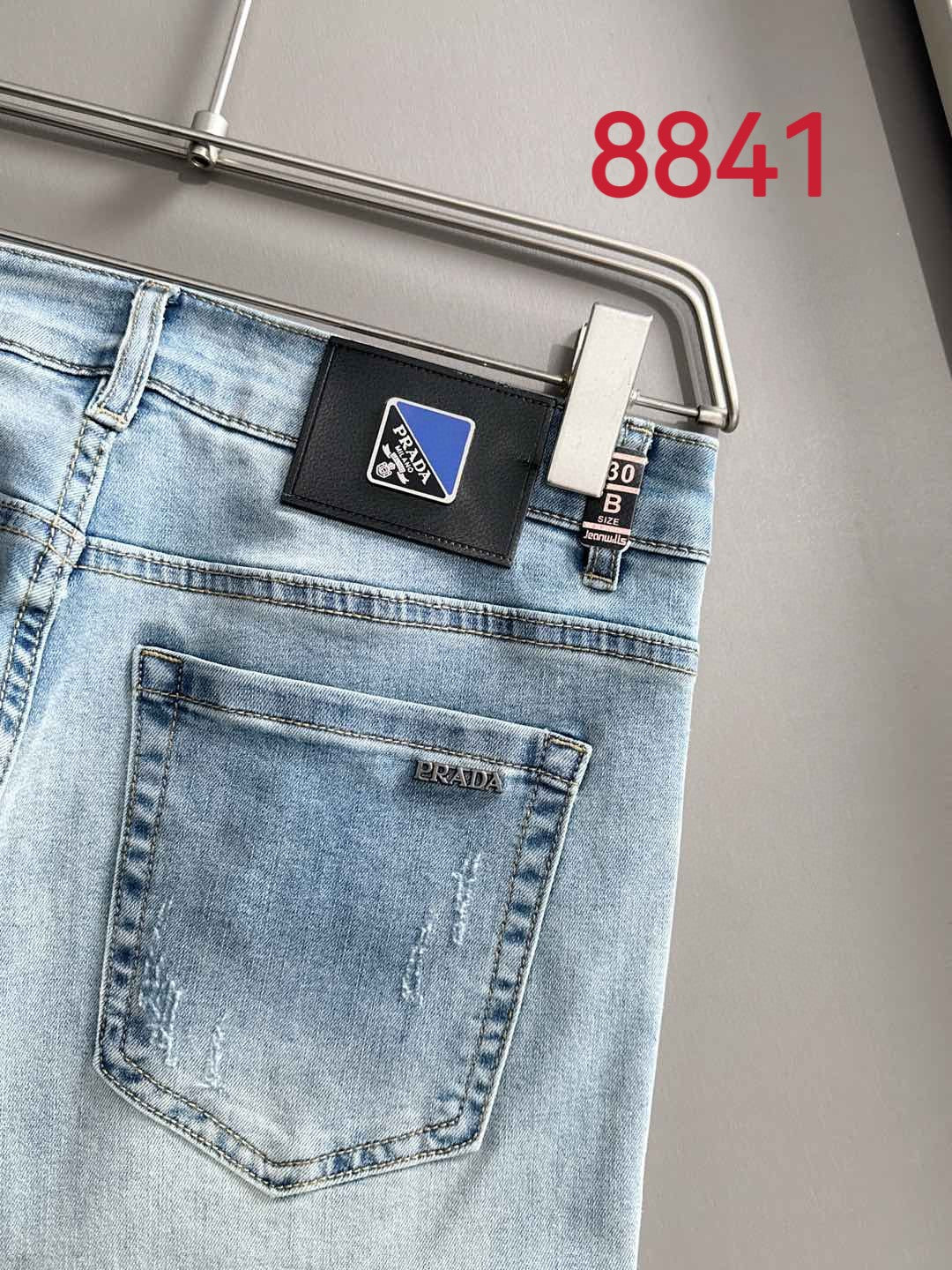 Light blue denim jeans logo label and back pocket close-up.
