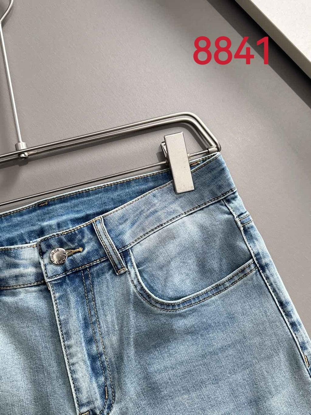 Light blue denim jeans waistband and front pocket close-up.