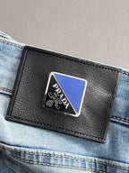 PRADA leather patch on light blue denim waistband close-up.