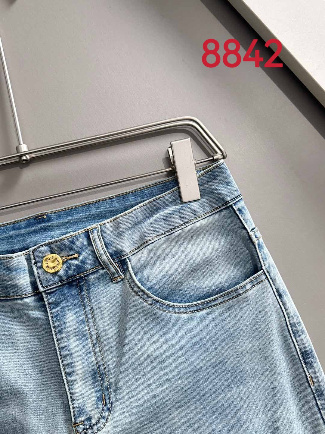 Light blue denim jeans with button fly, belt loops, and stitched waistband