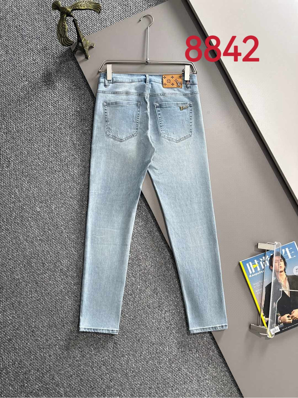 Light blue denim jeans with belt loops and front pockets on hanger