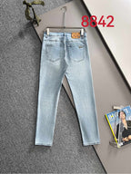Light blue denim jeans with belt loops and front pockets on hanger