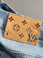 Brown monogram leather waistband patch with LV-style logo on denim