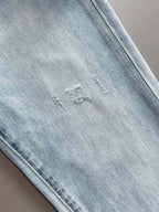 Light blue denim jeans with subtle distressing and neat seam stitching