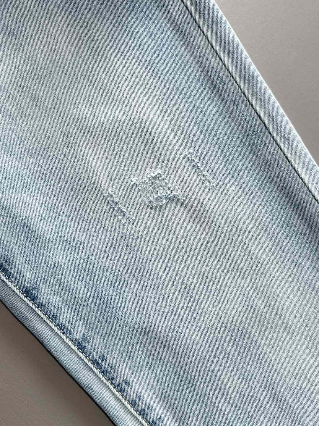 Light blue denim jeans with subtle distressing and neat seam stitching