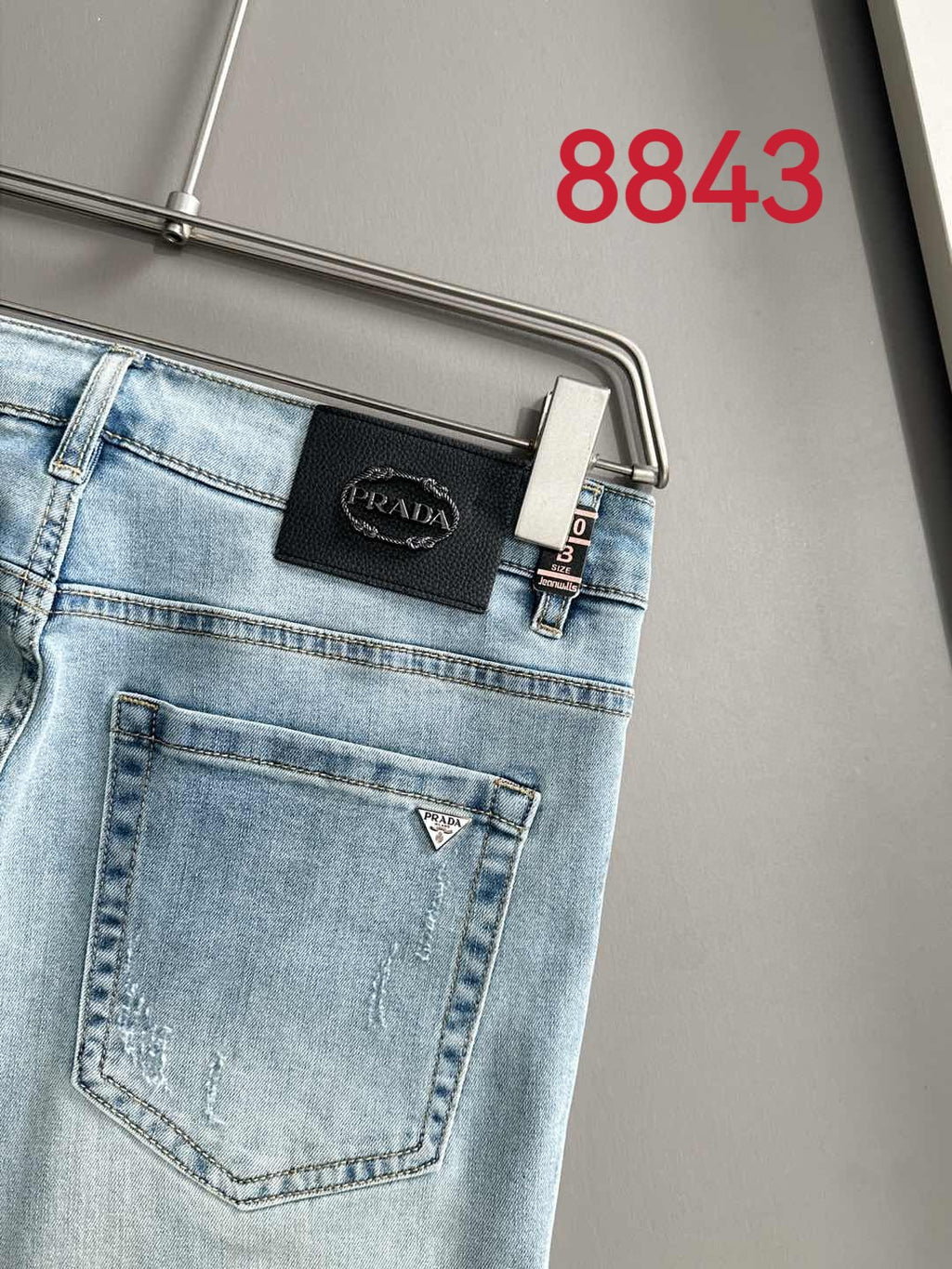 Light blue denim waistband with Prada leather patch and belt loops.