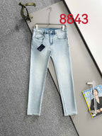Light blue denim pants on hanger with straight legs and five-pocket design.