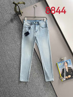 Light blue denim pants on hanger with belt loops and front pockets